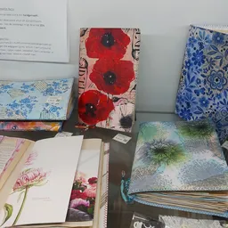 Uitgestalde stoffering en notitieboeken met bloemmotieven en patronen op een tafel
