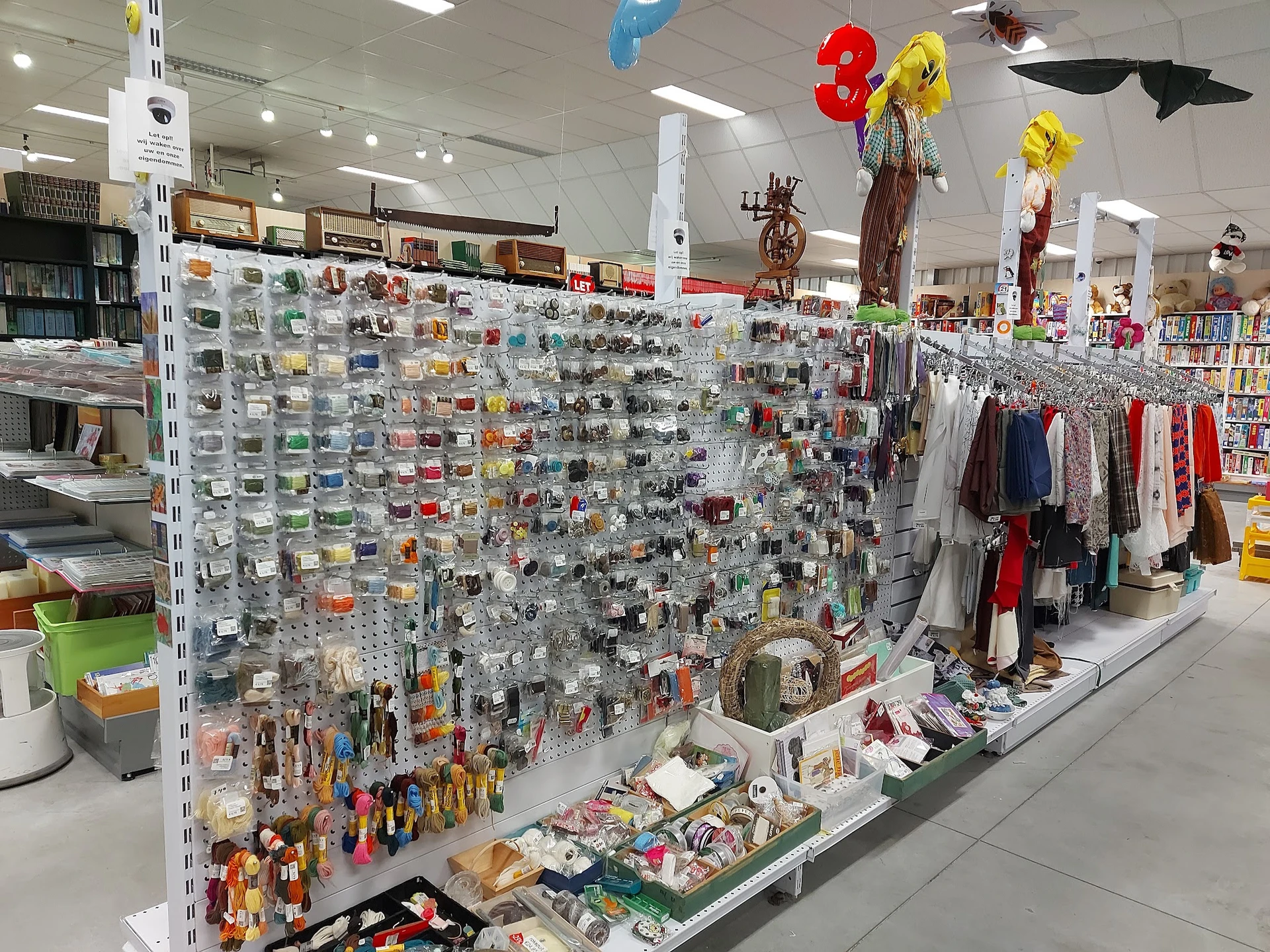 Uitgebreide stellingen met honderden kleine artikelen, speelgoed en accesoires in een kringloopwinkel