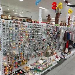 Uitgebreide stellingen met honderden kleine artikelen, speelgoed en accesoires in een kringloopwinkel