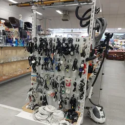 Uitgestalde elektrische kabels en snoeren op een wit rek in de kringloopwinkel