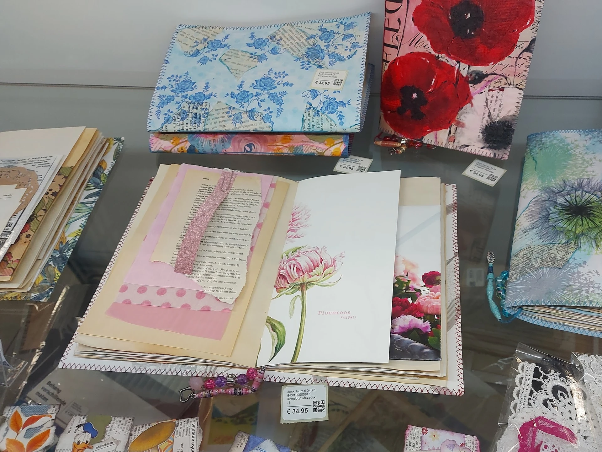 Uitgestalde notitieboeken, schetsblokken en decoratieve items met bloemmotieven op tafel