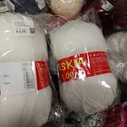 Wollen bollen in verschillende kleuren, verpakt in plastic met prijskaartjes en merklabels