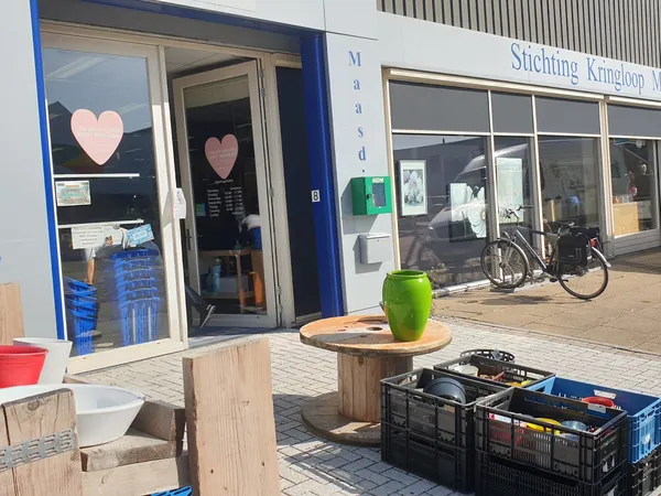 Winkelgevel met blauwe deurpui, hartje op raam, en terras met groene bloempot vooraan