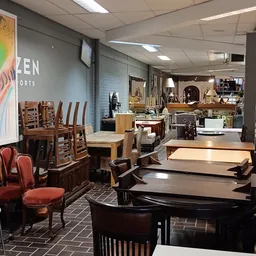 Winkelvloer met uitgestalde meubels: tafels, stoelen en kasten in verschillende stijlen