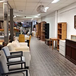 Winkelvloer met meubels, fauteuils en kasten uitgestald in een kringloopwinkel