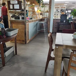 Winkelinterieur met houten tafels, stoelen, toonbank en stellingen met spullen
