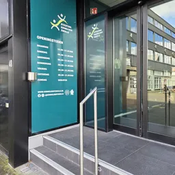 Openingstijden op een turquoise bord met dagen en tijden van maandag tot zondag