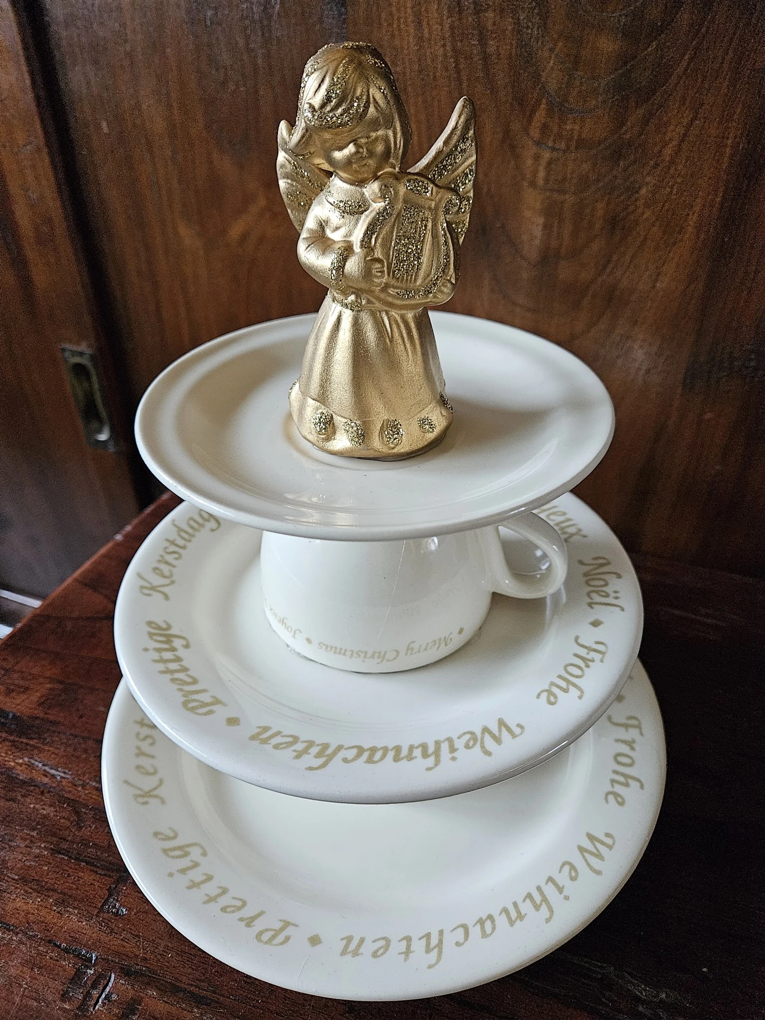 Wit porseleinen servieswerk met gouden engelfiguur als deksel, gestapeld in drie lagen