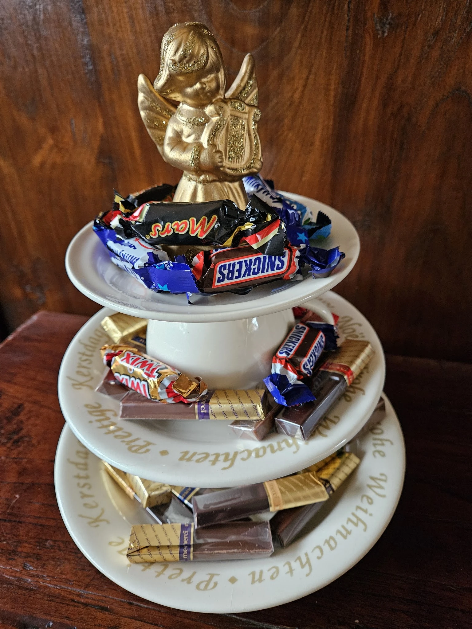 Decoratieve schaal met chocoladerepen en snoepjes, met gouden decoratie bovenop