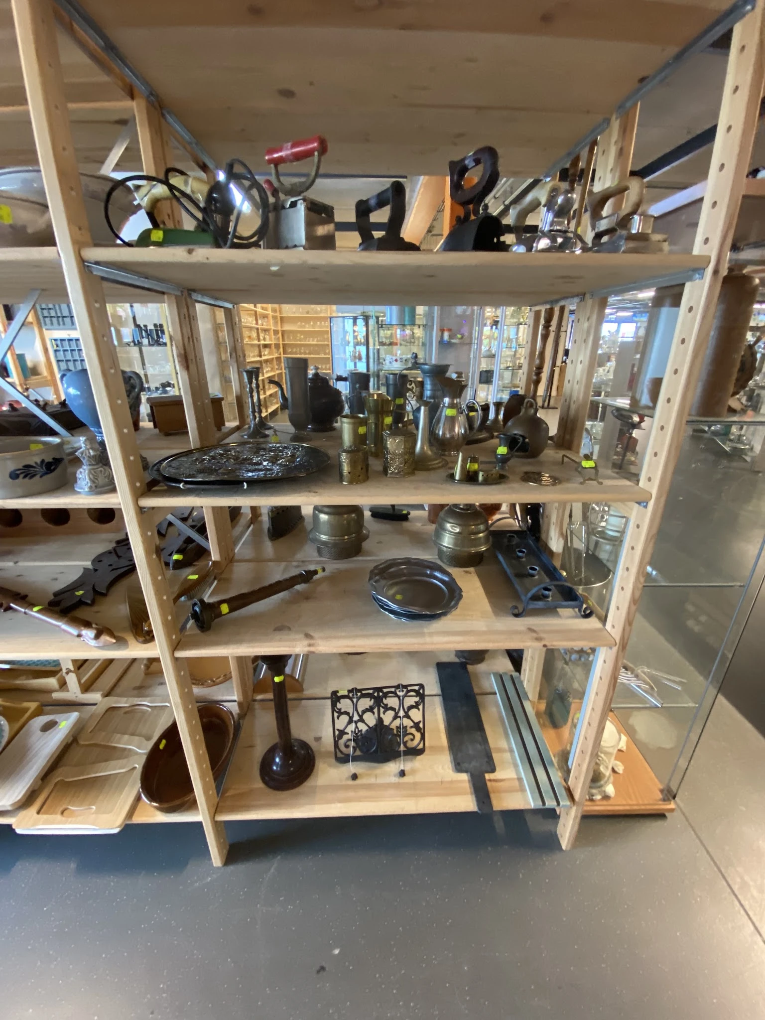 Houten stellingkast met diverse tweedehands huishoudelijke artikelen en decoratieve items
