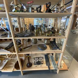 Houten stellingkast met diverse tweedehands huishoudelijke artikelen en decoratieve items