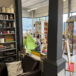 Winkelinterieur met boekenkasten, speelgoed en verschillende rekken met tweedehands spullen