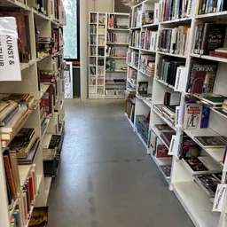 Gangpad met boekenrekken aan beide zijden in een kringloopwinkel