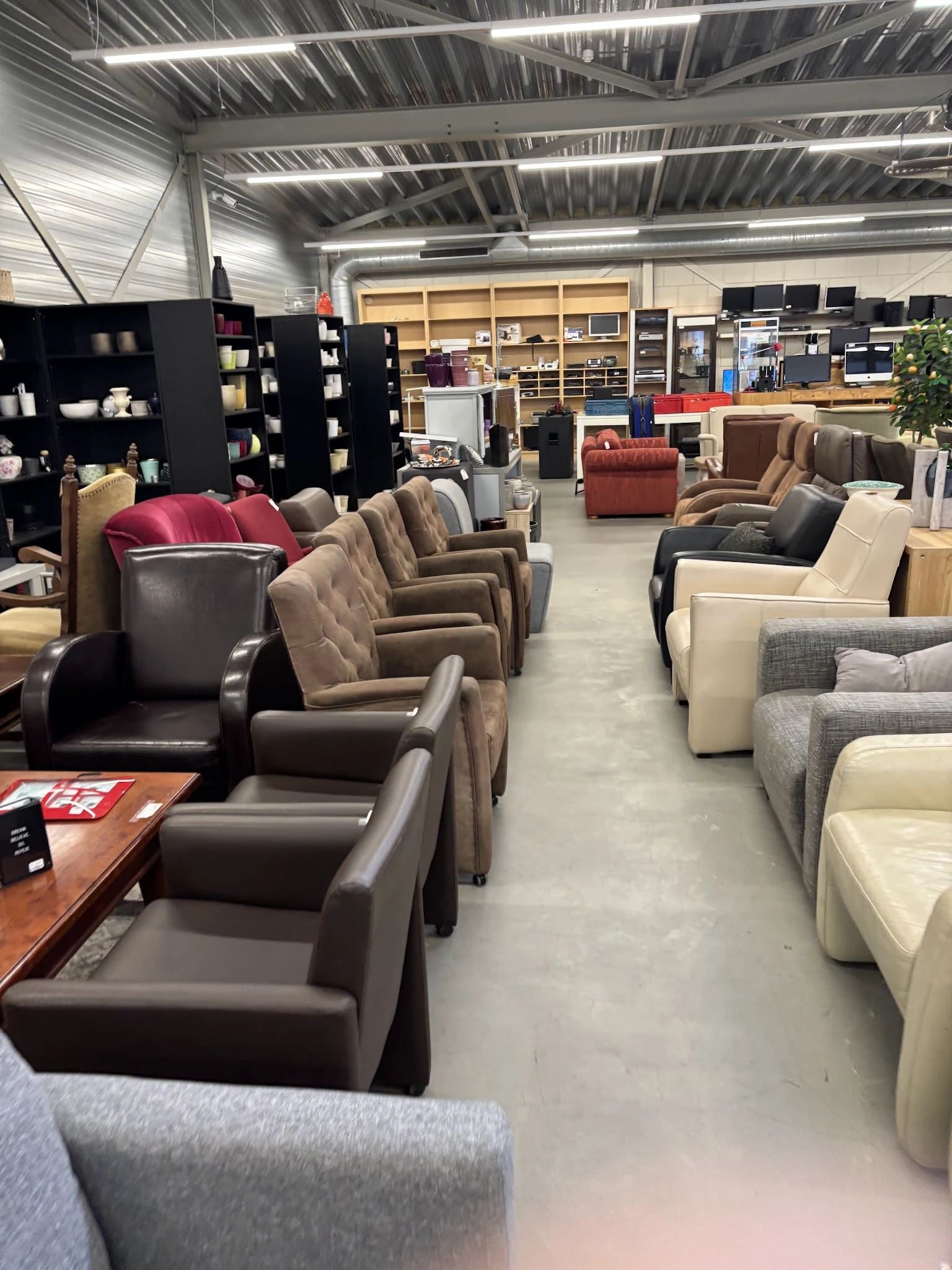 Diverse fauteuils en stoelen in verschillende kleuren en stijlen in de winkel
