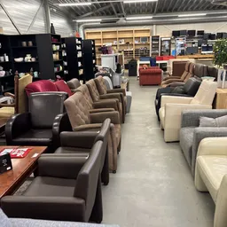 Diverse fauteuils en stoelen in verschillende kleuren en stijlen in de winkel