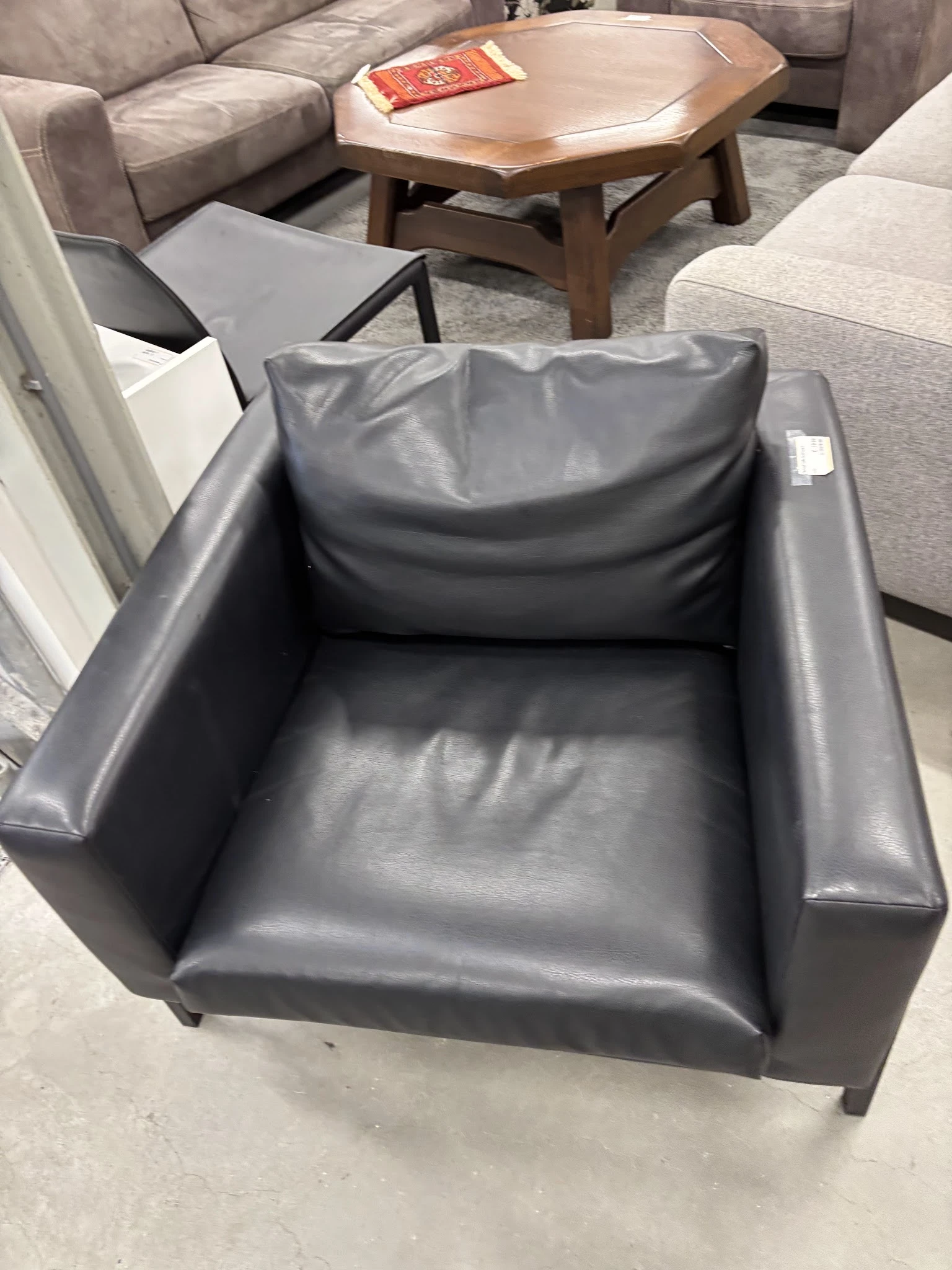 Grijze leren fauteuil met hoge rugleuning en zijarmleuningen