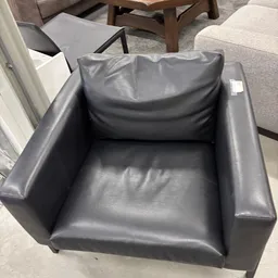 Grijze leren fauteuil met hoge rugleuning en zijarmleuningen