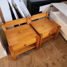 Twee houten kinderstoeltjes met rugleuning naast elkaar op de winkelboer