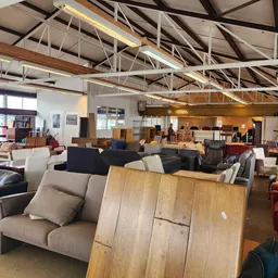 Overzicht van de winkelruimte met diverse meubels zoals banken, stoelen en tafels uitgestald