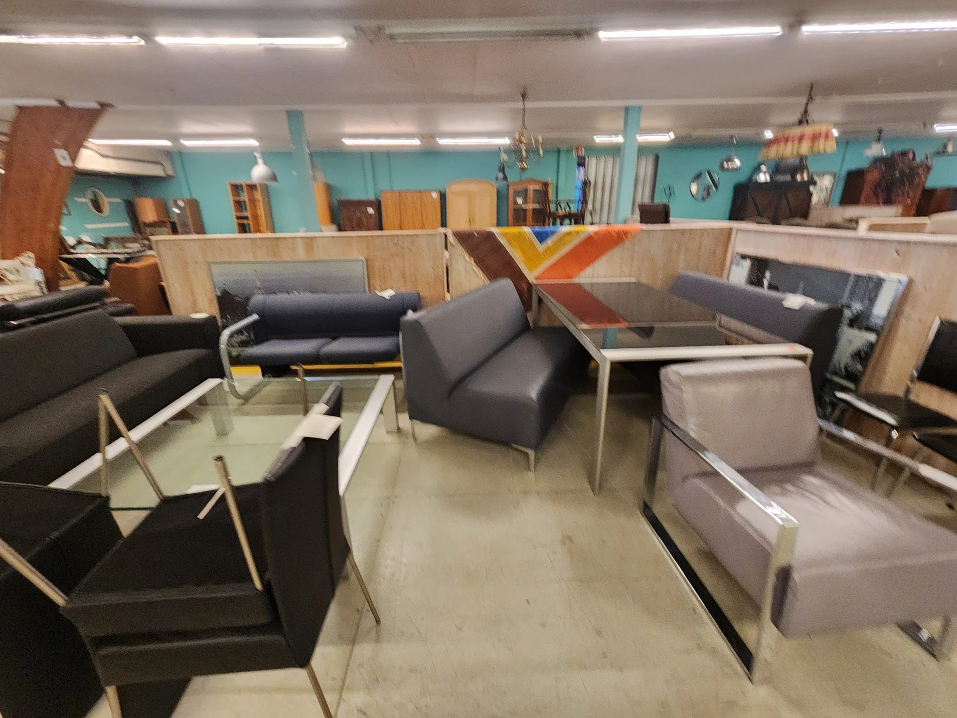 Winkelvloer met diverse meubels uitgestald: fauteuils, banken en salontafels in verschillende kleuren en stijlen