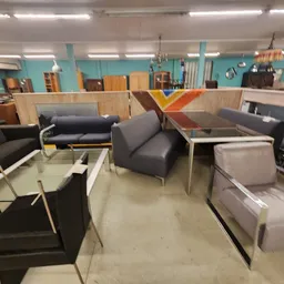 Winkelvloer met diverse meubels uitgestald: fauteuils, banken en salontafels in verschillende kleuren en stijlen