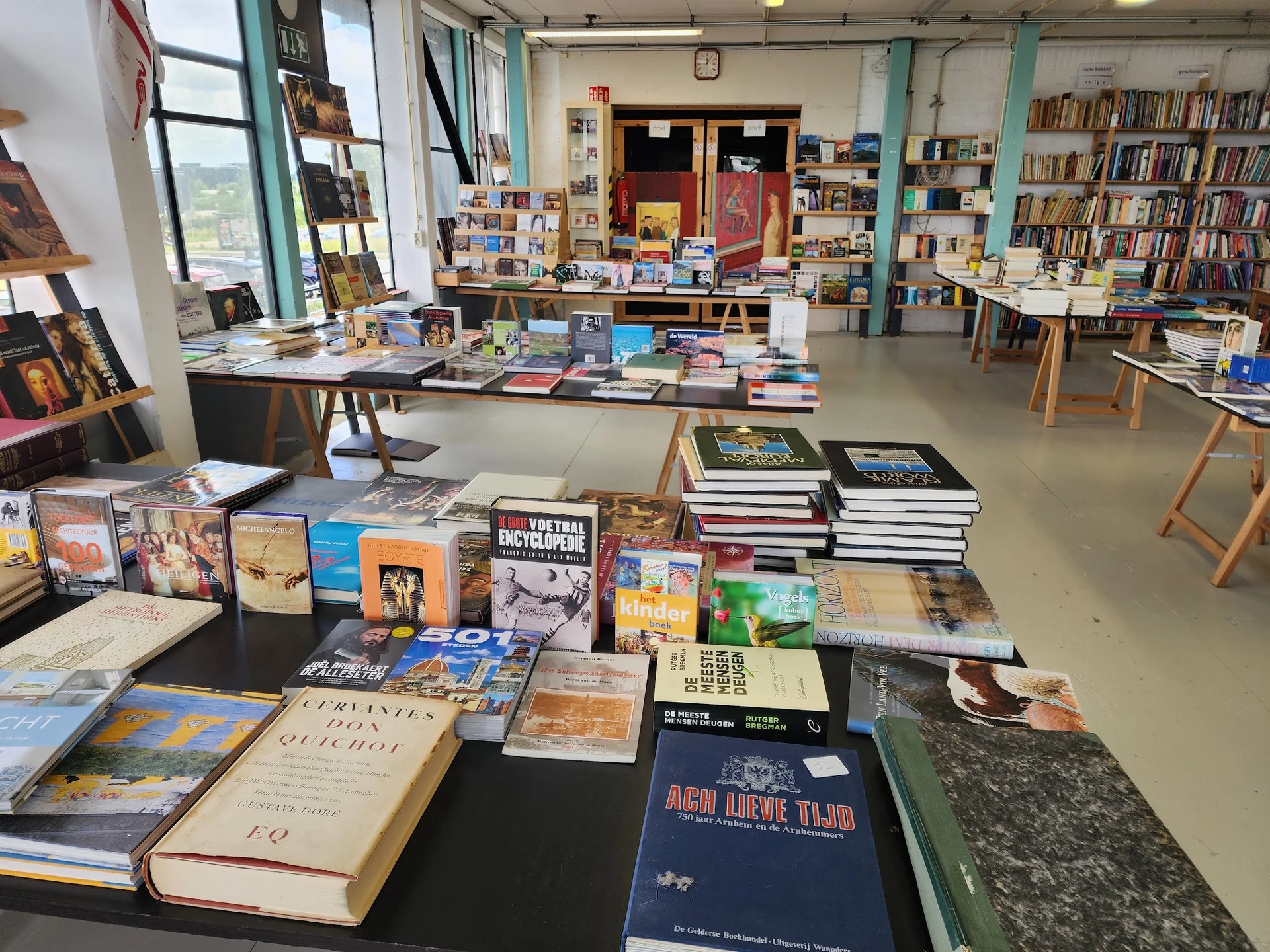 Boekenwinkel interieur met boekenrekken, tafels vol met boeken en stripboeken uitgestald