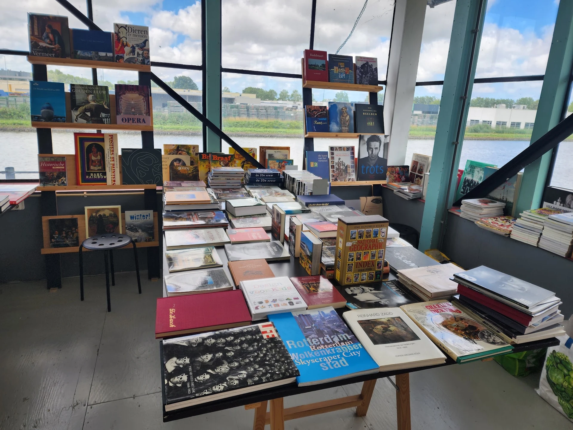 Uitgestalde boeken, kunstboeken en designs op tafels en muurkasten in de winkel