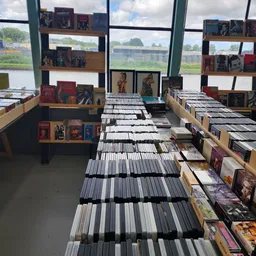Lange tafels vol met cd's en dvd's uitgestald in de winkel