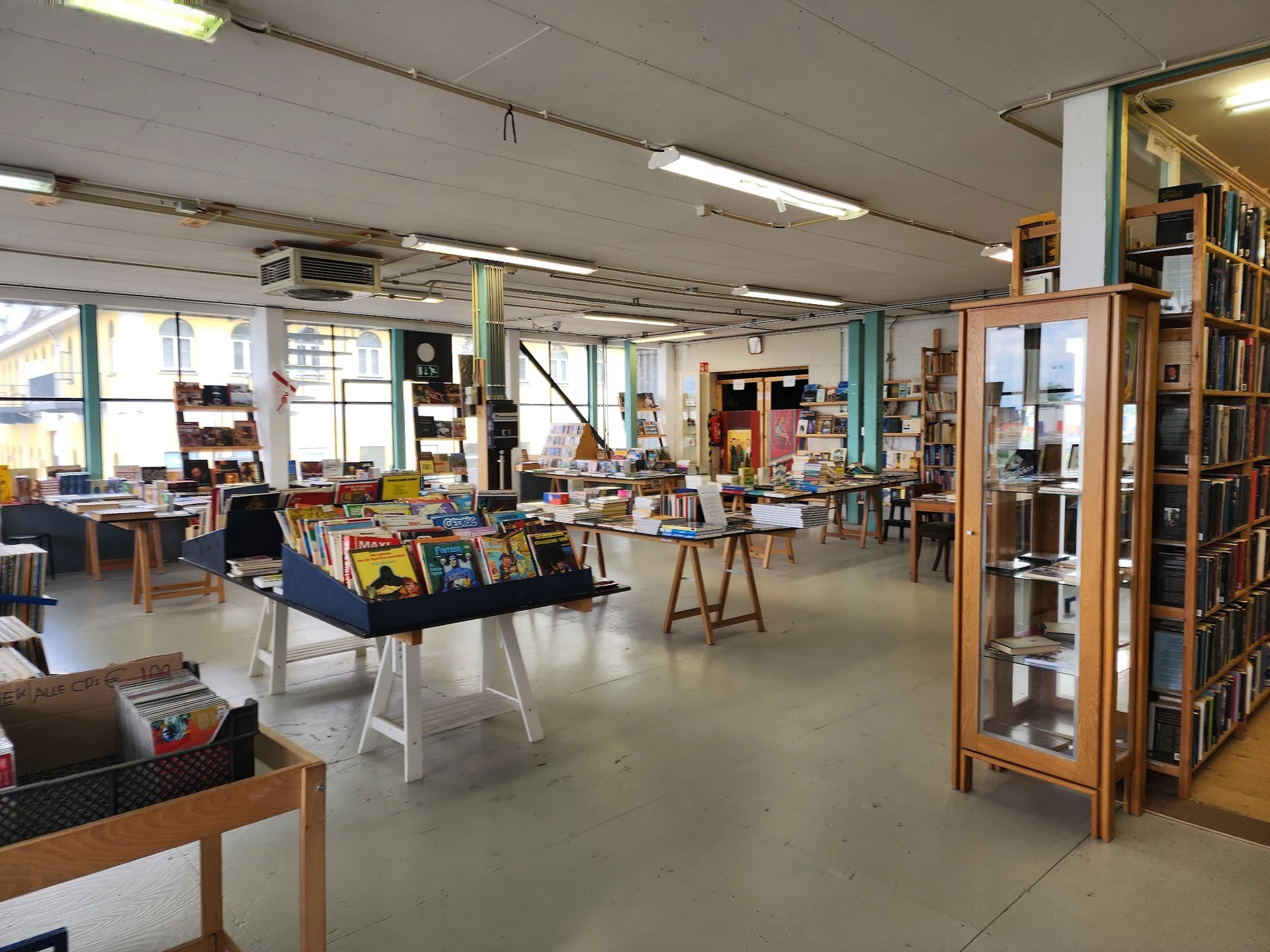Ruim winkelinterieur met boekenkasten, zitmeubels en displayrekken met tweedehands spullen