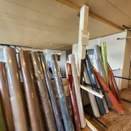 Uitgestalde rollen behang en vloerbedekking in verschillende kleuren en patronen