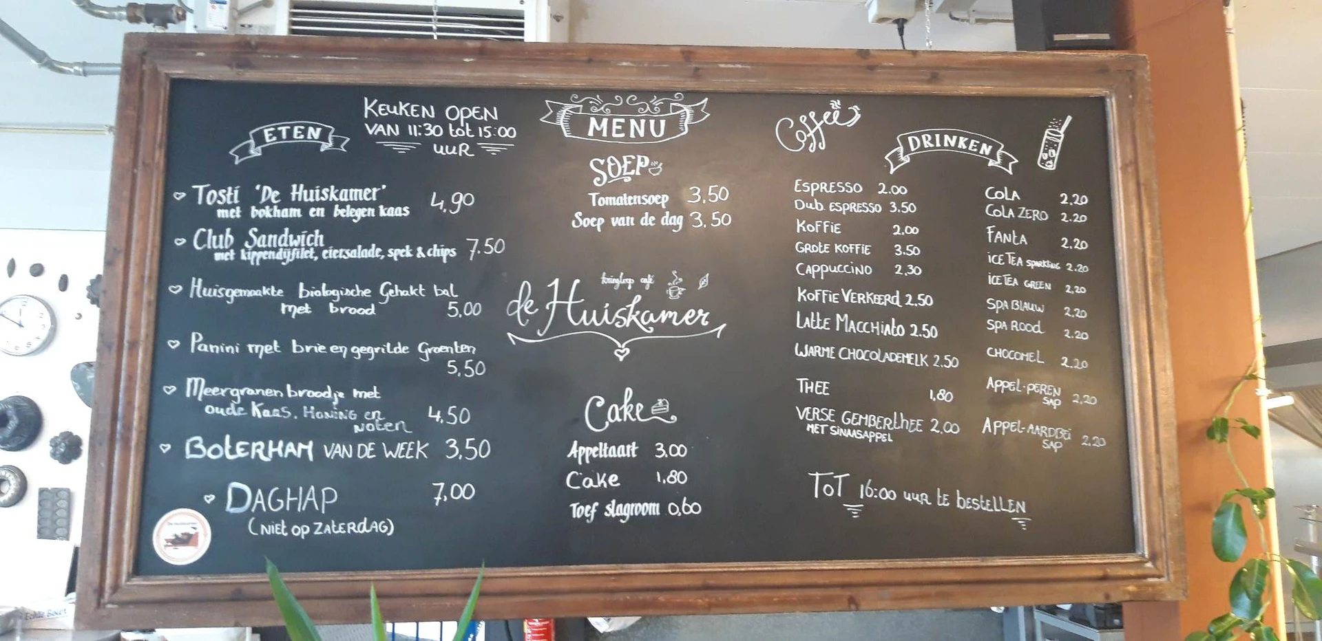 Menukaart op krijtbord met gerechten, dranken en prijzen in een lunchroom