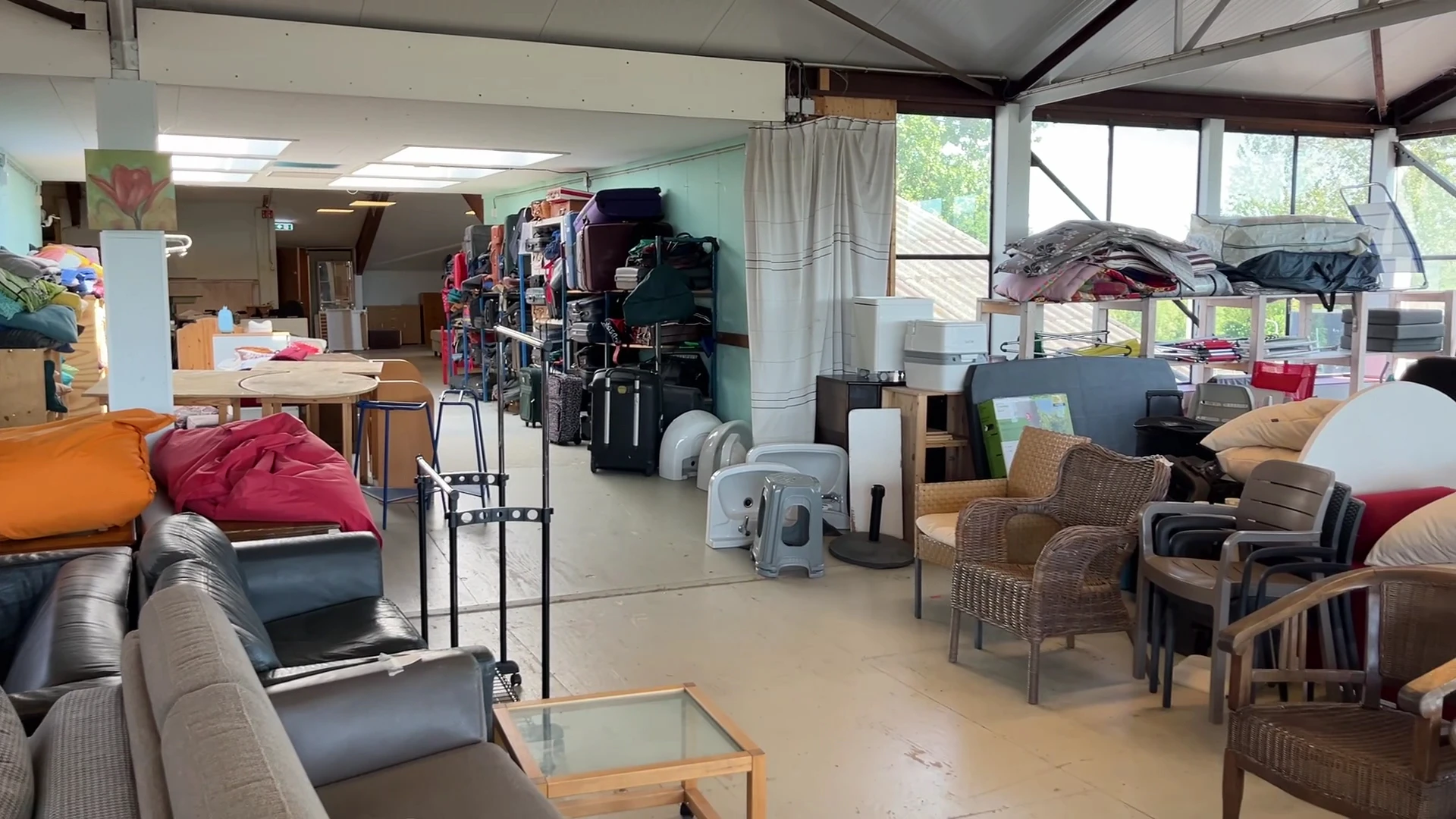 Winkelvloer met diverse meubels, kledingrekken en huishoudelijke artikelen