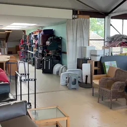 Winkelvloer met diverse meubels, kledingrekken en huishoudelijke artikelen
