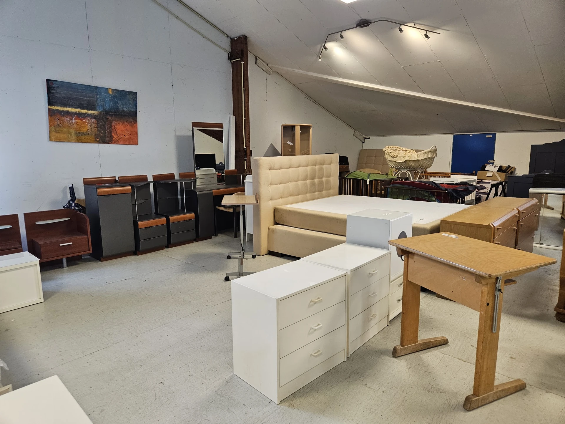 Overzicht van de winkelvloer met meubels zoals bedden, kasten, tafels en stoelen uitgestald