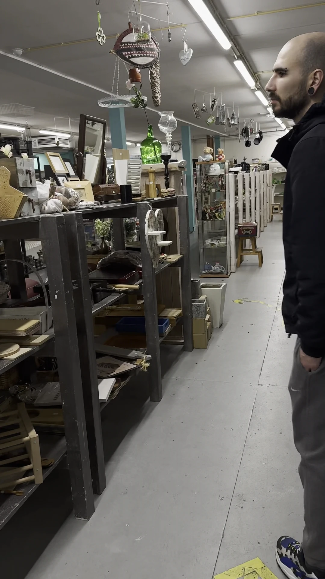 Winkelinterieur met glazen vitrines en stellingen langs een gang