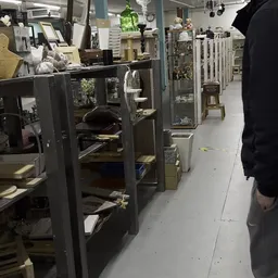 Winkelinterieur met glazen vitrines en stellingen langs een gang