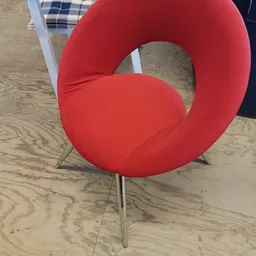 Rode moderne stoel met metallic poten op houten vloer