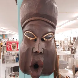 Houten Egyptisch hoofd met goudkleurige accenten rond de ogen