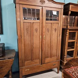Houten kast met glazen deuren en decoratieve carving op de panelen
