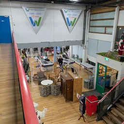 Overzicht van kringloopwinkel met diverse meubels, huisraad en kleding op de winkelvloer