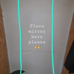 Scherm met tekst 'Place mirror here please' en twee groene verticale lijnen