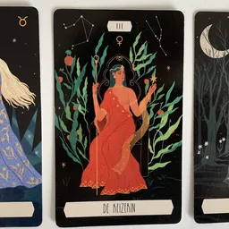 Drie tarotkaarten met illustraties van vrouwenfiguren en astrologische symbolen op zwarte achtergrond
