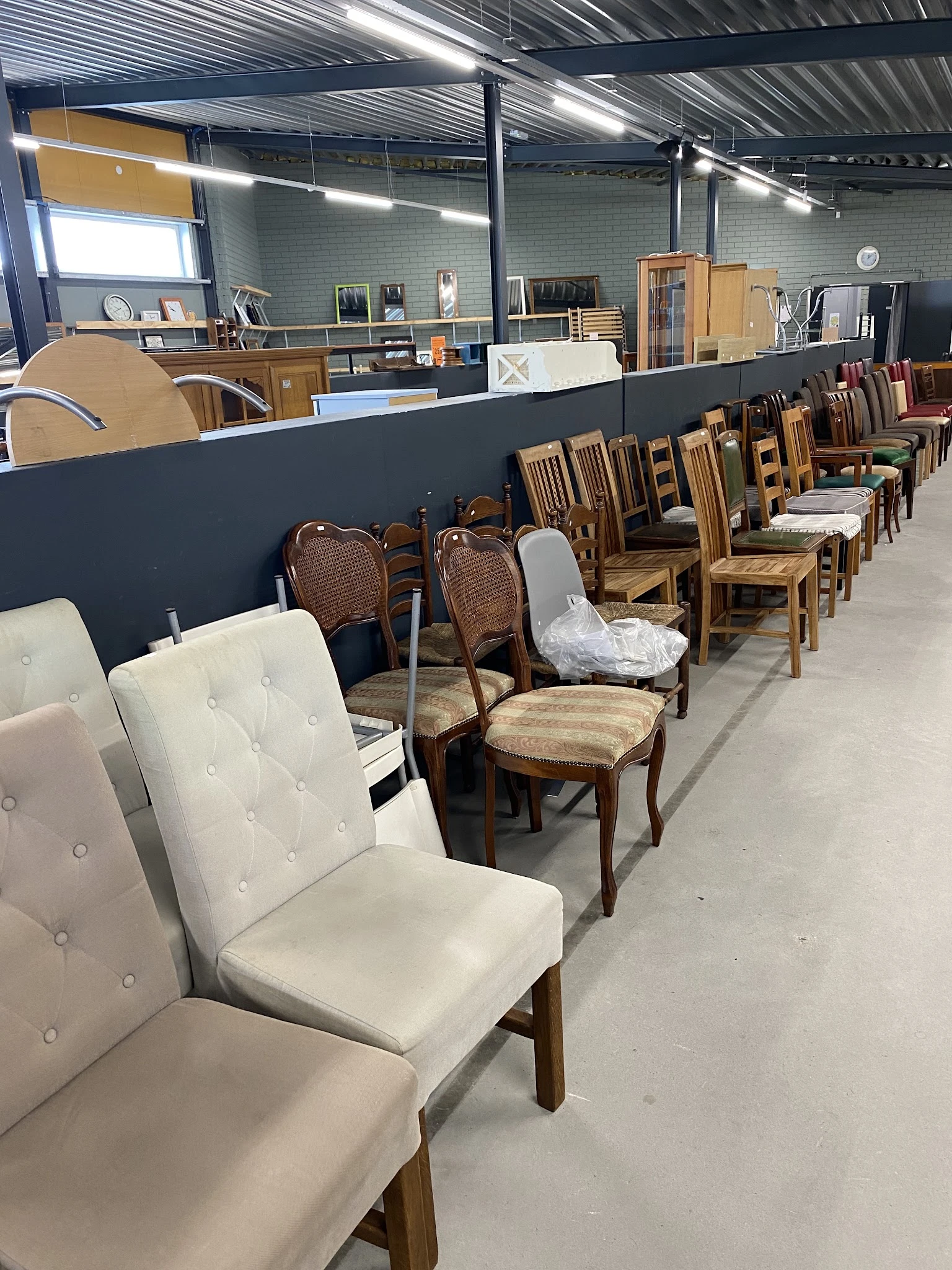 Rij met verschillende stoelen en eetkamerstoelen uitgestald in de winkel
