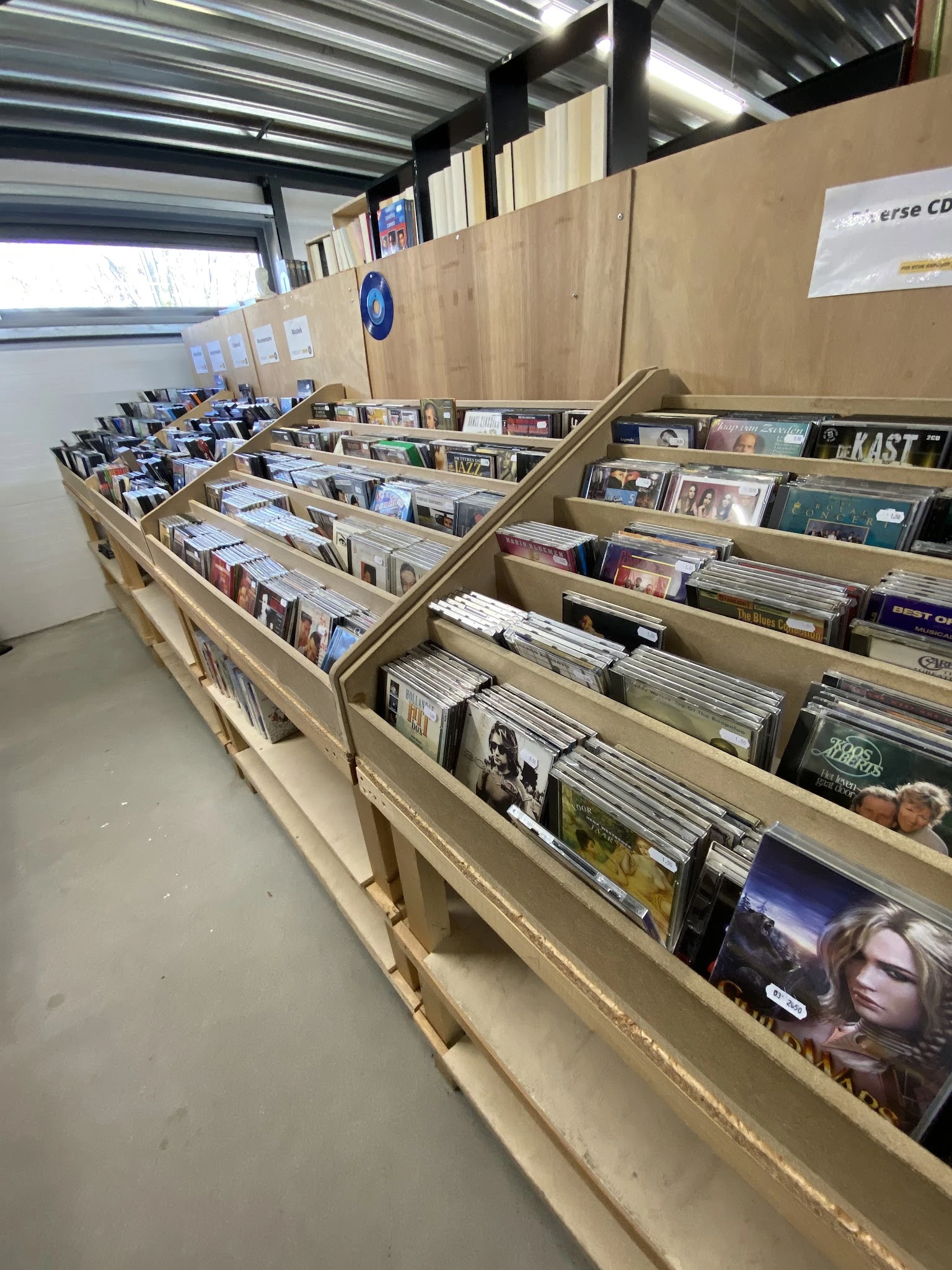Houten stellingen met CD's en dvd's uitgestald in verschillende vakken