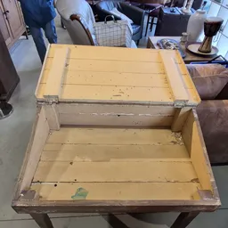 Houten kist of koffer met geel-beige kleurig hout en metalen hoeken, open uitgestald