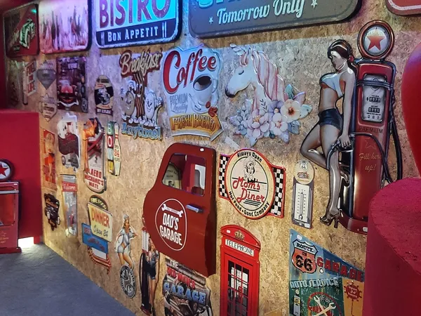 Muurdecoratie met vintage neonborden, retro kunstobjecten en nostalgiaplaten in een kringloopwinkel