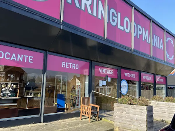 Roze gevel van kringloopwinkel Kringloopmania met uitstallingen en ingangsdeur zichtbaar