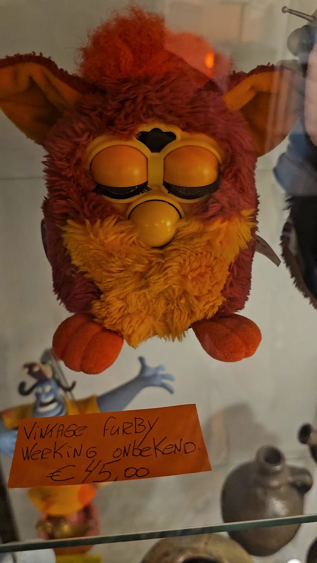 Furby-speelgoed met oranje en rood pluche, gesloten ogen en oranje poten