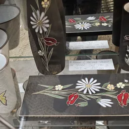 Zwarte serviesset met wit en rood bloemenpatroon, bestaande uit borden, kopjes en schalen