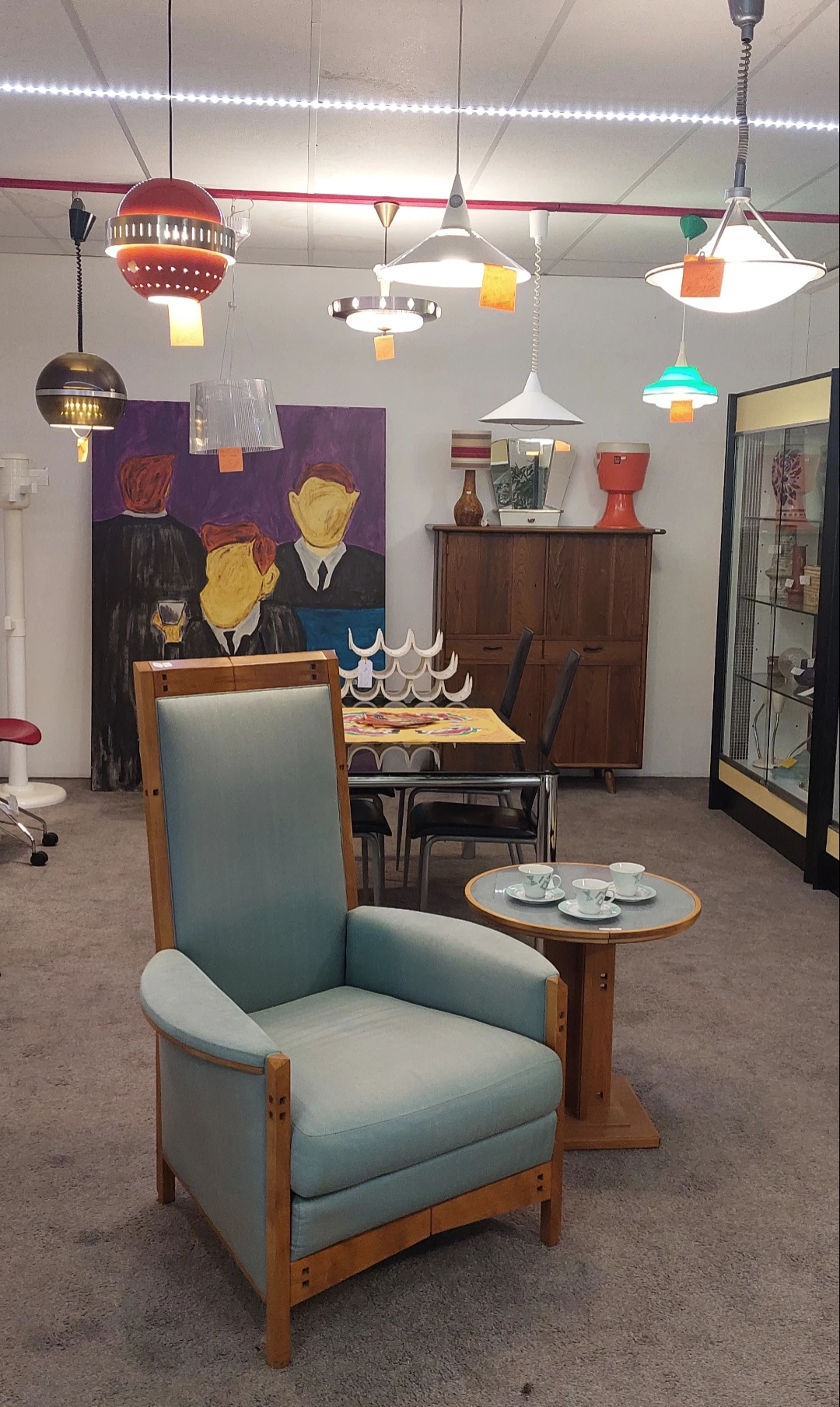 Winkelvloer met vintage meubels, kunstwerk en servies op display in kringloopwinkel